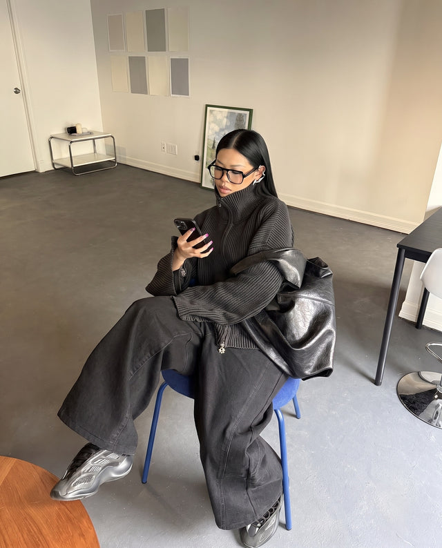 Seated on a blue chair, wearing the Morph Ear Cuff