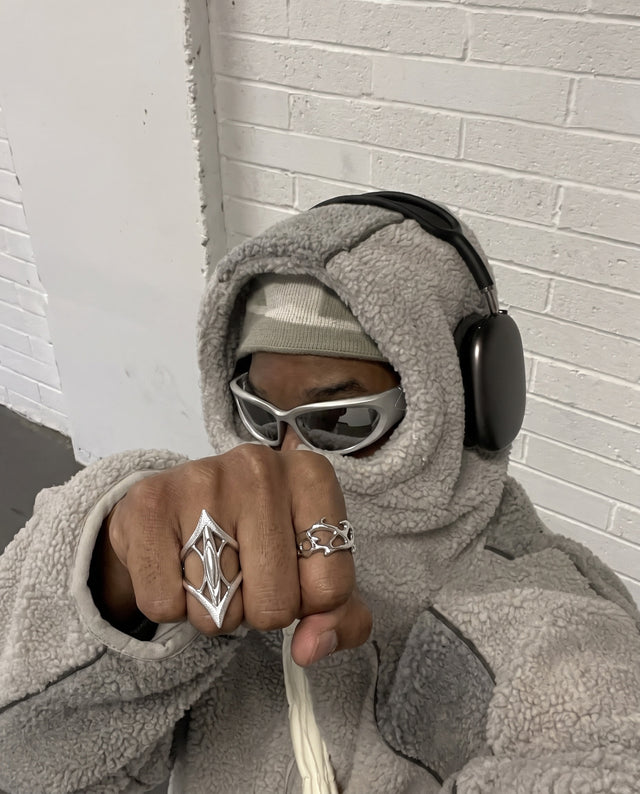 Fist to camera against white brick, wearing the Zenith Ring