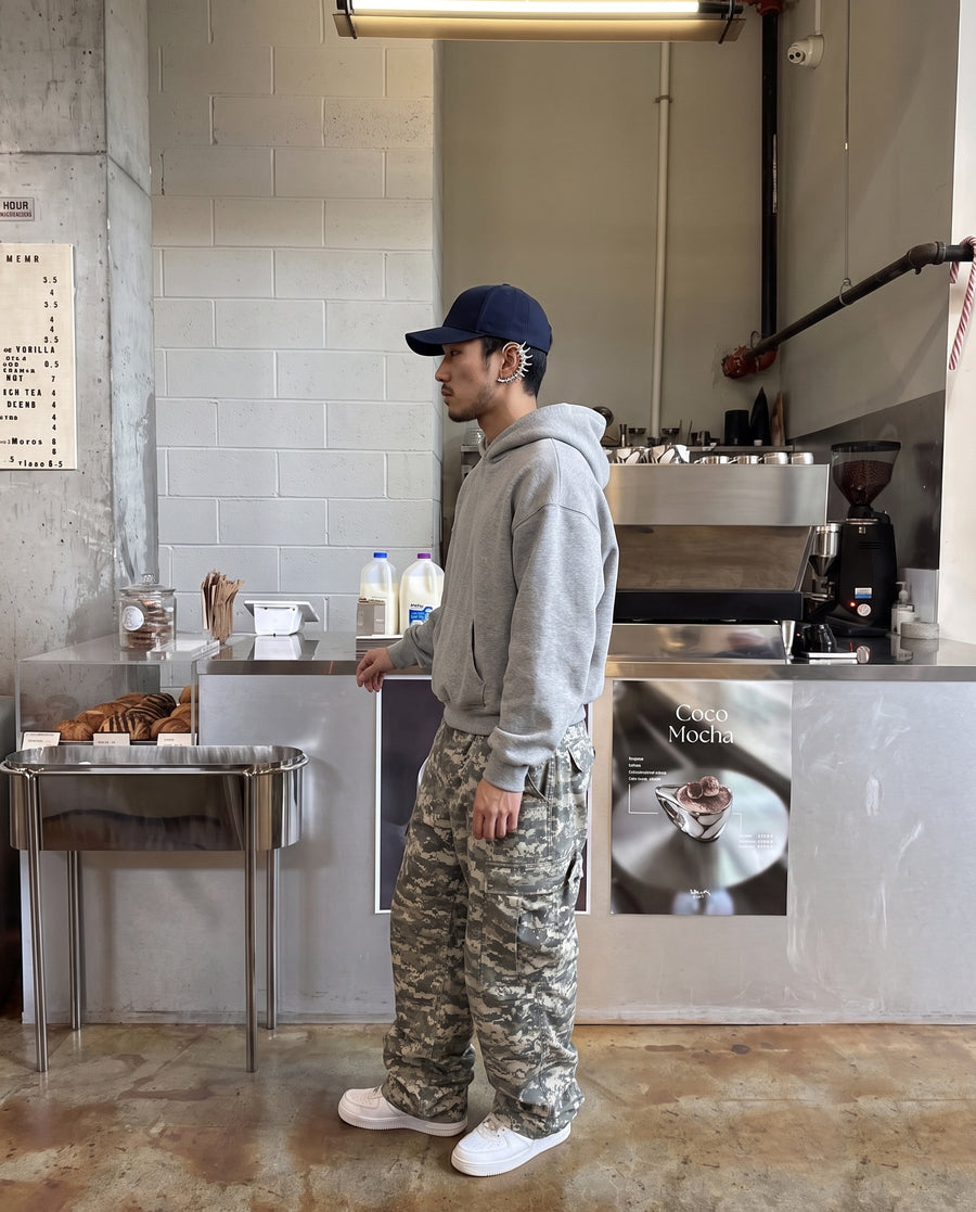 Profile at a cafe counter, wearing the Exoskeleton Ear Cuff