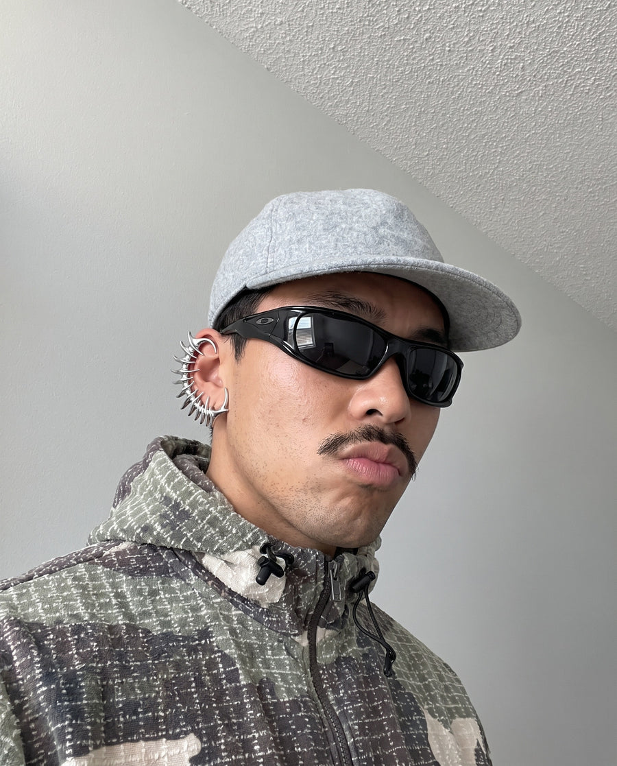 Cap and camo fleece, wearing the Exoskeleton Ear Cuff
