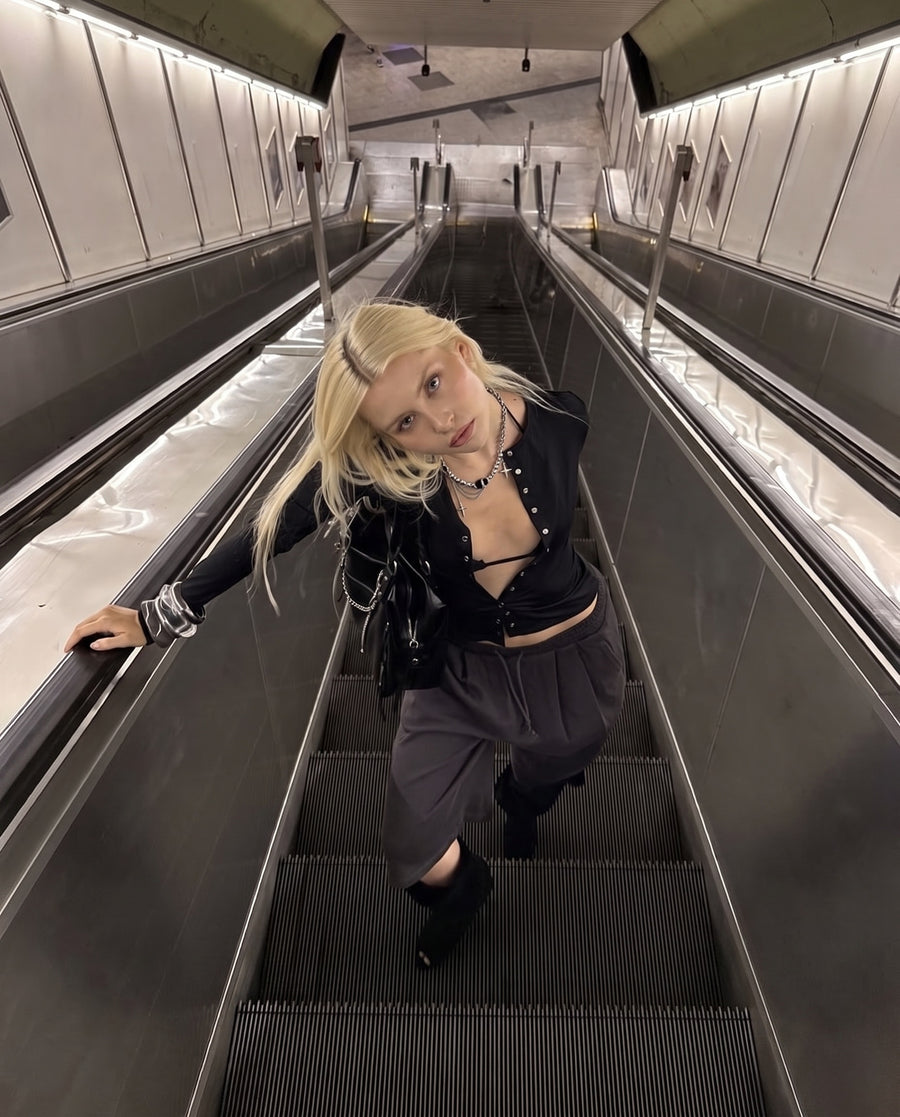 On an escalator, wearing the Anarchy Necklace