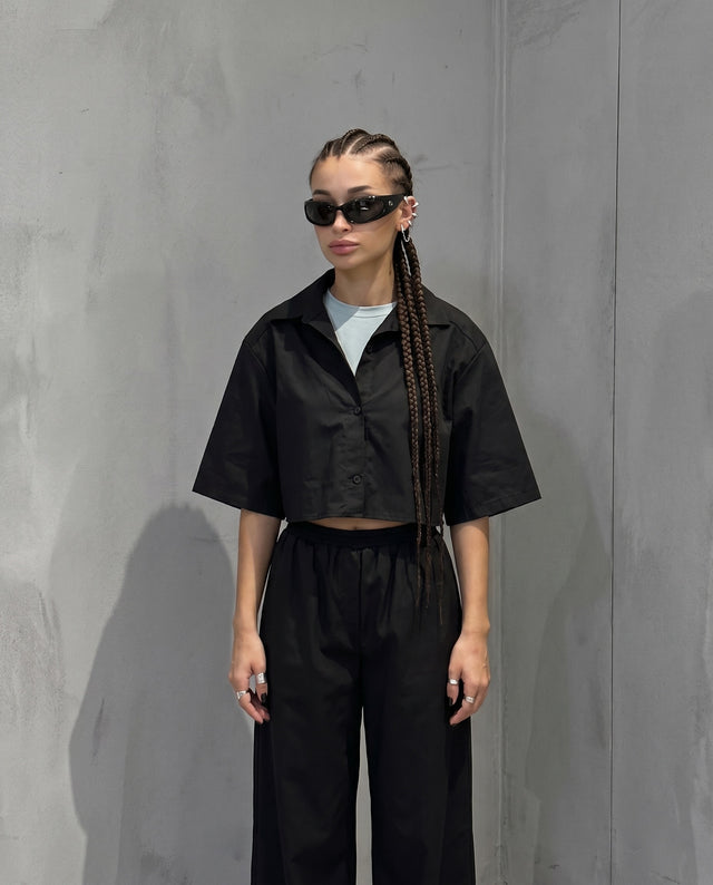 Cropped shirt against a gray wall, wearing the Pierce Ear Cuff
