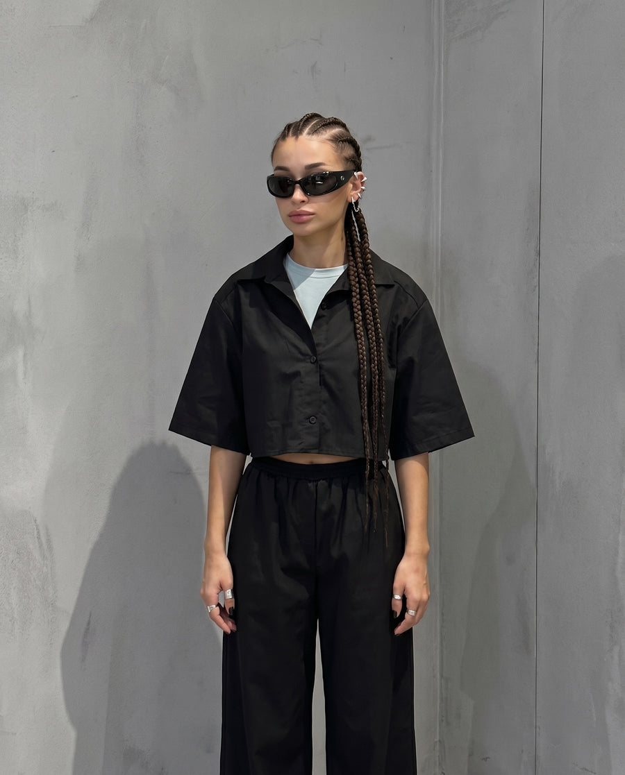 Cropped shirt against a gray wall, wearing the Pierce Ear Cuff