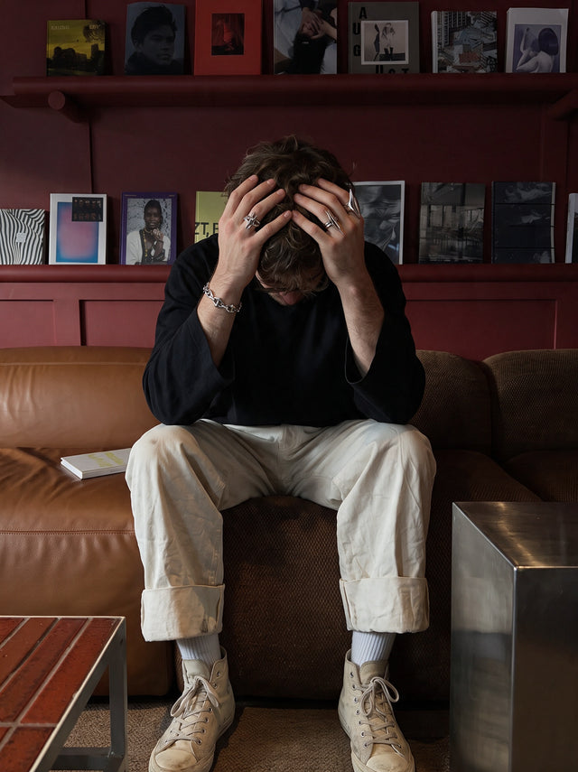Seated on a red-room sofa, wearing the Splinter Ring