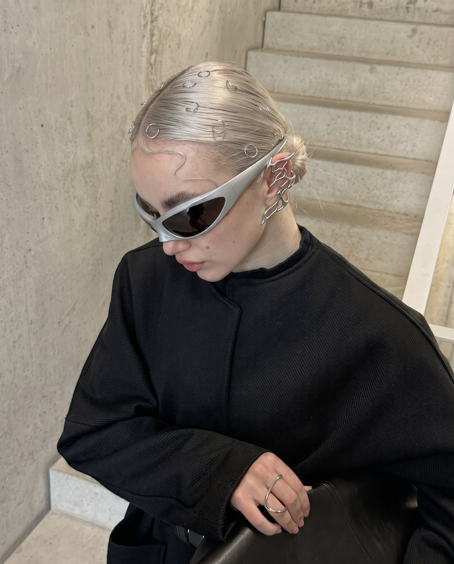 Platinum hair on concrete steps, wearing the Fusion Ear Cuff