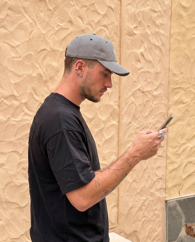 Phone in hand against a stucco wall, wearing the Razor Ring